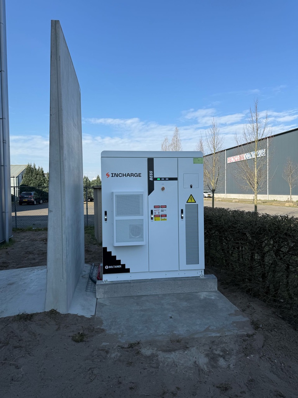 Outdoor battery storage cabinet installed beside an industrial unit